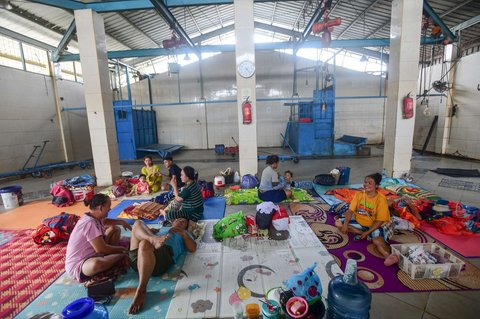 Sejumlah warga terdampak banjir mengungsi di tempat jagal sapi di Kampung Cantiga, Petir, Cipondoh, Kota Tangerang, pada Selasa (8/7/2025). Kawasan Tangerang saat ini dikepung banjir akibat meluapnya Kali Angke. Sementara, ketinggian banjir yang merendam Kampung Cantiga mencapai 1,8 meter.