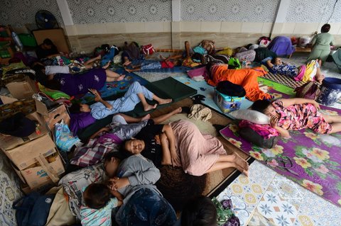 Sejumlah warga terdampak banjir mengungsi di tempat jagal sapi di Kampung Cantiga, Petir, Cipondoh, Kota Tangerang, pada Selasa (8/7/2025). Kawasan Tangerang saat ini dikepung banjir akibat meluapnya Kali Angke. Sementara, ketinggian banjir yang merendam Kampung Cantiga mencapai 1,8 meter.