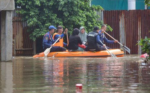 Petugas pemadam kebakaran mengevakuasi warga yang terjebak banjir di Kampung Cantiga, Petir, Cipondoh, Kota Tangerang, pada Selasa (8/7/2025). Kawasan Tangerang saat ini dikepung banjir akibat meluapnya Kali Angke. Sementara, ketinggian banjir yang merendam Kampung Cantiga mencapai 1,8 meter.