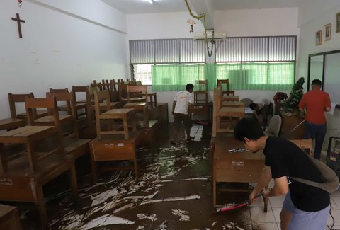 Petugas membersihkan ruang kelas setelah banjir merendam SMAN 60 Jakarta di kawasan Duren Tiga, Jakarta, Selasa (8/7/2025).