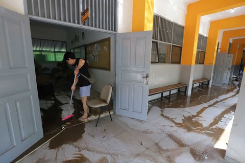Petugas membersihkan ruang kelas setelah banjir merendam SMAN 60 Jakarta di kawasan Duren Tiga, Jakarta, Selasa (8/7/2025).