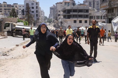 Dua gadis berlari  setelah serangan Israel menghantam tenda yang menampung warga Palestina yang mengungsi di Kota Gaza, Selasa (08/07/2025).