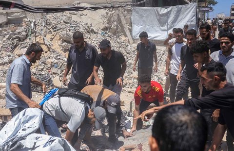 Warga melakukan evakuasi seorang anak yang terluka tergeletak di lokasi serangan Israel di samping tenda yang menampung menampung warga Palestina yang mengungsi di Kota Gaza, Selasa (08/07/2025).