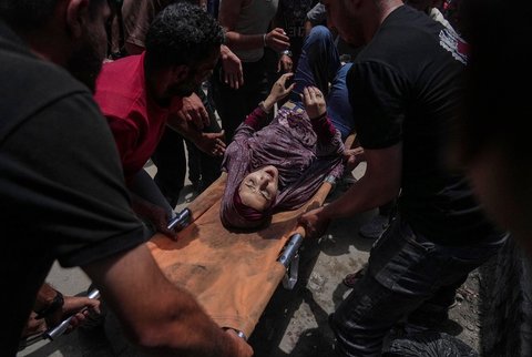 Seorang wanita terluka  dievakuasi di lokasi serangan Israel di samping tenda yang menampung menampung warga Palestina yang mengungsi di Kota Gaza, Selasa (08/07/2025).<br />Foto AP/Jehad Alshrafi