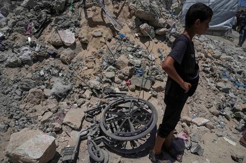 Seorang anak berdiri di lokasi serangan Israel di samping tenda yang menampung menampung warga Palestina yang mengungsi di Kota Gaza, Selasa (08/07/2025).