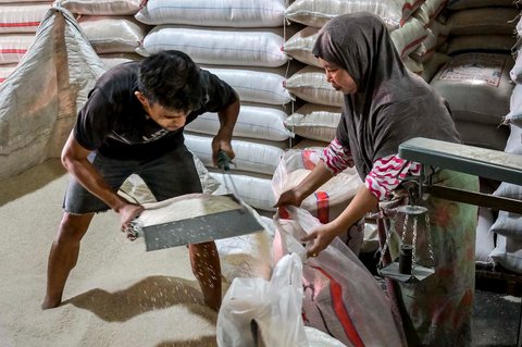 Pekerja menyiapkan pesanan beras  pelanggan di pasar induk  beras  Cipinang, Jakarta, Rabu (09/07/2025).  AFP/ Bay Ismoyo