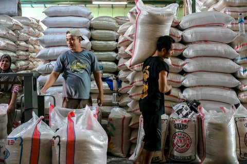 Pekerja menyiapkan pesanan beras  pelanggan di pasar induk  beras  Cipinang, Jakarta, Rabu (09/07/2025).  AFP/ Bay Ismoyo