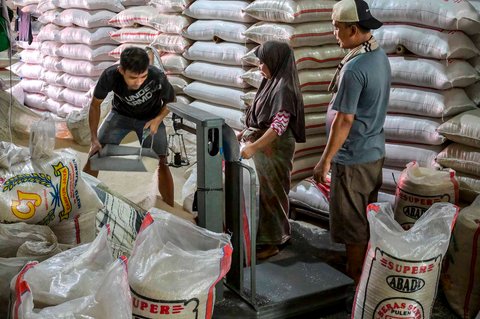 Pekerja menyiapkan pesanan beras  pelanggan di pasar induk  beras  Cipinang, Jakarta, Rabu (09/07/2025).