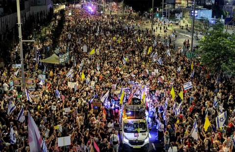 Para pengunjuk rasa berkumpul dalam demonstrasi yang diselenggarakan oleh keluarga para sandera Israel yang ditawan di Jalur Gaza di luar kantor pusat Kementerian Pertahanan di Tel Aviv, Israel, Sabtu (09/08/2025) malam.