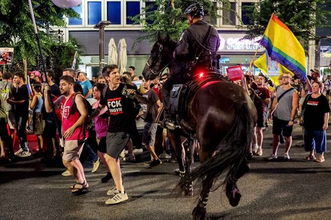 Seorang pengunjuk rasa berhadapan dengan polisi Israel berkuda saat berupaya membubarkan orang-orang yang berkumpul untuk demonstrasi di luar kantor pusat Kementerian Pertahanan di Tel Aviv, Israel, Sabtu (09/08/2025) malam.