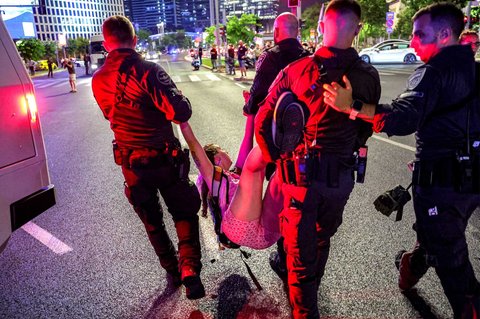 Polisi Israel menahan seorang pengunjuk rasa menyusul demonstrasi yang diselenggarakan oleh keluarga para sandera Israel yang ditawan di Jalur Gaza di luar kantor pusat Kementerian Pertahanan di Tel Aviv, Israel, Sabtu (09/08/2025) malam.