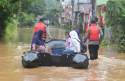 Anggota Brimob Polda Metro Jaya mengevakuasi warga menggunakan perahu karet setelah banjir  merendam kawasan Perumahan Villa Pamulang, Kelurahan Pondok Petir, Kecamatan Bojongsari, Kota Depok, Jawa Barat, Minggu (10/8/2025).