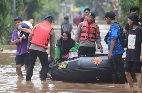 Anggota Brimob Polda Metro Jaya mengevakuasi warga menggunakan perahu karet setelah banjir  merendam kawasan Perumahan Villa Pamulang, Kelurahan Pondok Petir, Kecamatan Bojongsari, Kota Depok, Jawa Barat, Minggu (10/8/2025).
