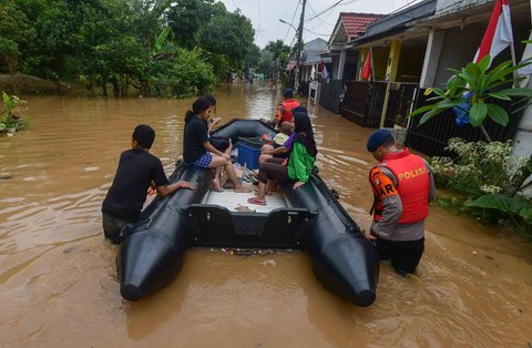 Aanggota Brimob Polda Metro Jaya mengevakuasi warga menggunakan perahu karet setelah banjir  merendam kawasan Perumahan Villa Pamulang, Kelurahan Pondok Petir, Kecamatan Bojongsari, Kota Depok, Jawa Barat, Minggu (10/8/2025).