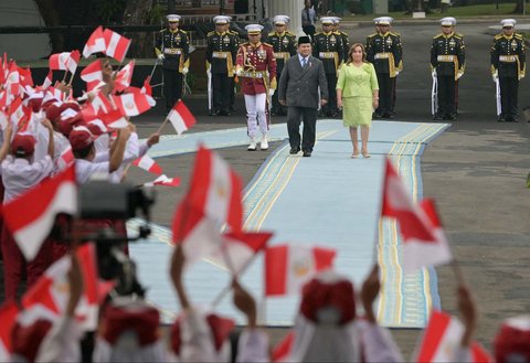 Presiden Indonesia Prabowo Subianto bersama Presiden Peru Dina Boluarte memeriksa barisan kehormatan presiden di tengah anak-anak yang mengibarkan bendera kedua negara di Istana Merdeka, Jakarta, Senin (11/08/2025).
