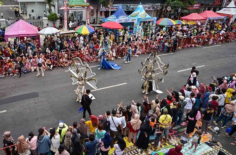 Pserta dengan kostum bertema simfoni mengikuti parade sepanjang 3,6 kilometer dalam Jember Fashion Carnival di Jember, Jawa Timur, Minggu (10/08/2025).