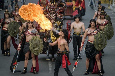 Seorang perempuan yang berkostum Tembok Besar Tiongkok dan berkostum api ikut serta dalam Jember Fashion Carnival di Jember, Jawa Timur, Minggu (10/08/2025).