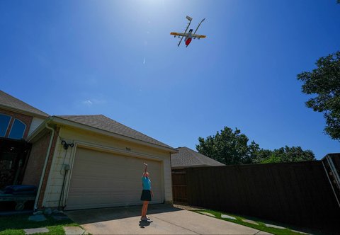 Pelanggan melambaikan tangan ke arah drone yang tiba di rumahnya untuk mengantarkan barang, di Frisco, Texas, AS ,Kamis (31/07/2025).