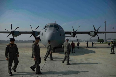 Personel TNI AU berjalan di dekat pesawat kargo C-130 sebelum lepas landas untuk mengangkut kontainer bantuan kemanusiaan yang akan diterjunkan kepada warga Gaza  di Bandara Halim Perdana Kusuma, Jakarta, Rabu, (13/08/2025).