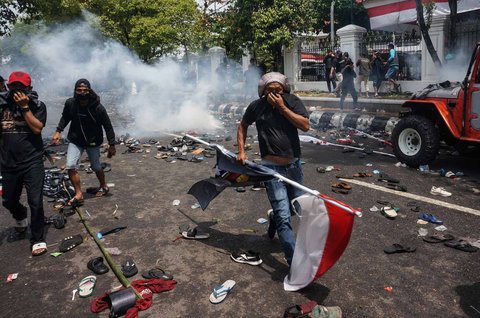 Warga berlari menghindari gas air mata saat aksi ribuan warga  di depan Kantor Bupati Pati, Jawa Tengah. Rabu (13/08/2025).