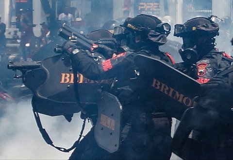 Petugas polisi melepaskan gas air mata saat aksi ribuan warga  di depan Kantor Bupati Pati, Jawa Tengah. Rabu (13/08/2025).