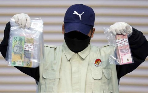 Petugas KPK menunjukkan barang bukti uang tunai saat konferensi pers penahanan tersangka kasus dugaan suap izin pemanfaatan kawasan hutan di Gedung Merah Putih KPK, Jakarta, Kamis (14/08/2025)