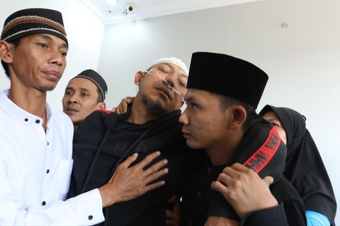 Suami mendiang tak kuasa menahan sedih saat jenasah komedian Mpok Alpa yang  memiliki nama asli Nina Carolina saat tiba di rumah duka di kawasan Ciganjur, jakarta Selatan, Jumat (15/08/2025).
