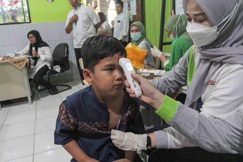 Petugas kesehatan Puskesmas Batu Sari mengukur suhu siswa sebelum menyuntikan vaksin imunisasi Campak-Rubella (MR) ke murid kelas 1 saat pelaksanaan bulan imunisasi anak sekolah (BIAS) 2025 di SDN Batu Jaya, Kota Tangerang, Banten, Jumat (15/08/2025).