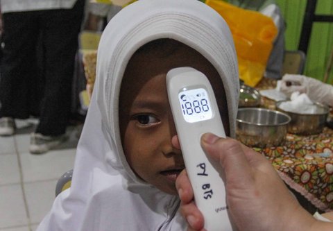 Petugas kesehatan Puskesmas Batu Sari mengukur suhu badan sebelum menyuntikan vaksin imunisasi Campak-Rubella (MR) ke murid kelas 1 saat pelaksanaan bulan imunisasi anak sekolah (BIAS) 2025 di SDN Batu Jaya, Kota Tangerang, Banten, Jumat (15/08/2025).
