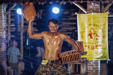 Pekerja pabrik genteng berpose saat mengikuti kompetisi binaraga tradisional di sebuah pabrik genteng di Jatiwangi, Jawa Barat (11/08/2025