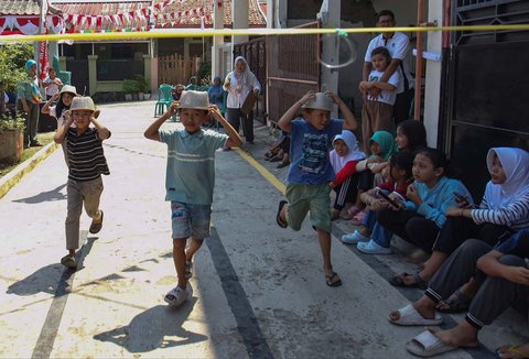 Anak-anak saat mengikuti lomba mengaitkan topi menyambut HUT Kemerdekaan RI ke 80  di Perum Depok Alam Lestari, Cibinong, Bogor, Jawa Barat, Sabtu (16/08/2025).