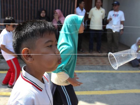 Anak-anak saat mengikuti lomba tiup gelas menyambut HUT Kemerdekaan RI ke 80  di Perum Depok Alam Lestari, Cibinong, Bogor, Jawa Barat, Sabtu (16/08/2025).