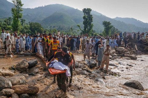 Petugas penyelamat mengangkut jenazah korban banjir bandang yang terjadi pada hari Jumat (15/08) setelah menemukannya di antara reruntuhan rumah yang rusak di Desa Qadir Nagar, Distrik Buner, Pakistan barat laut, Sabtu (16/08/2025).