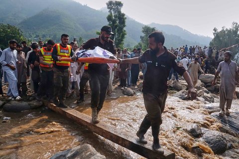 Petugas penyelamat mengangkut jenazah korban banjir bandang yang terjadi pada hari Jumat (15/08) setelah menemukannya di antara reruntuhan rumah yang rusak di Desa Qadir Nagar, Distrik Buner, Pakistan barat laut, Sabtu (16/08/2025).