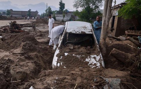 Warga melihat mobil yang terjebak lumpur di pinggiran Pir Baba, distrik Buner, di barat laut Pakistan, Sabtu (16/08/2025).