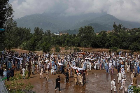 Warga membawa jenazah korban banjir bandang setelah salat jenazah di sebuah desa dekat Pir Baba, distrik Buner, di barat laut Pakistan,  Sabtu (16/08/2025).