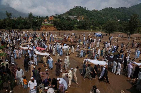 Warga membawa jenazah korban banjir bandang setelah salat jenazah di sebuah desa dekat Pir Baba, distrik Buner, di barat laut Pakistan,  Sabtu (16/08/2025).