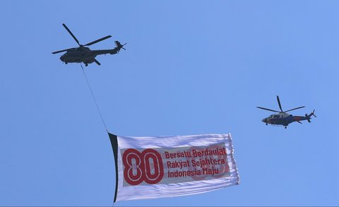 Helikopter TNI AU mengibarkan bendera HUT Kemerdekaan RI ke 80 saat perayaan HUT Kemerdekaan ke-80 RI di Kawasan Istana Negara, Jakarta, Minggu (17/8/2025)
