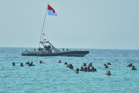 Prajurit penyelam Lanal Banten bersama personel gabungan terdiri TNI-Polri, Basarnas, BPBD, PSDKP Provinsi Banten, POSSI Provinsi Banten, Putera Puteri maritim Indonesia, Pramuka Saka Bahari dan berbagai Komunitas Diver saat melakukan Upacara HUT Kemerdekaan RI ke 80 di perairan Pulau Sangiang, Banten, Minggu (17/08/2025).