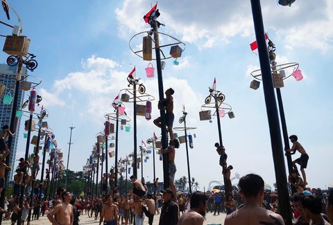 Peserta memanjat batang pinang saat lomba memperingati Kemerdekaan RI di Beach Pool, Ancol Jakarta, Minggu (17/08/2025