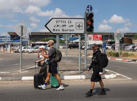 Anggota dinas keamanan Israel memeriksa kawah yang muncul dari rudal yang dikirimkan dari Yaman di luar bandara Ben Gurion Israel, Minggu (04/05/2025).