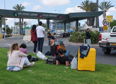 Anggota dinas keamanan Israel memeriksa kawah yang muncul dari rudal yang dikirimkan dari Yaman di luar bandara Ben Gurion Israel, Minggu (04/05/2025).