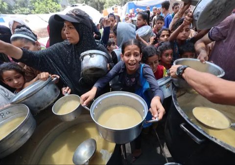 Warga Palestina berkumpul di titik distribusi bantuan yang didirikan oleh Yayasan Kemanusiaan Gaza (GHF) di dekat kamp pengungsi Nuseirat, Jalur Gaza Tengah pada 25 Juni 2025. (Eyad BABA/AFP)