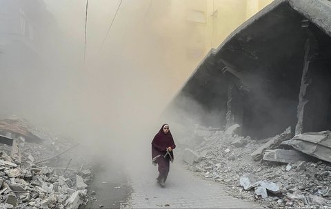Warga Palestina berlari menjauh dari lokasi serangan udara Israel di sebuah gedung enam lantai di lingkungan Saftawi, sebelah barat Jabalia, di Jalur Gaza utara, Selasa (19/08/2025) waktu setempat.