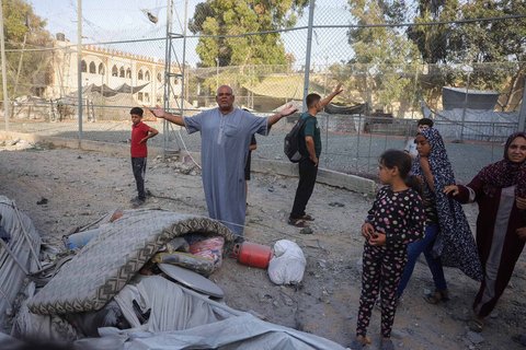 Warga Palestina berkumpul di dekat tenda pengungsian yang rusak akibat serangan Israel terhadap sebuah gedung enam lantai di lingkungan Saftawi, sebelah barat Jabalia, Jalur Gaza utara, Selasa (19/08/2025) waktu setempat.