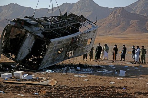 Sebuah derek menarik puing-puing bus di lokasi kecelakaan di distrik Guzara, provinsi Herat, Afganistan, Rabu (20/08/2025).
