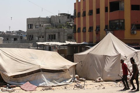 Warga Palestina menyaksikan roket yang ditembakkan pesawat tempur Israel menyasar sebuah gedung di Jabalia, Jalur Gaza utara, Rabu (20/08/2025). <br />AFP/ Bashar Taleb