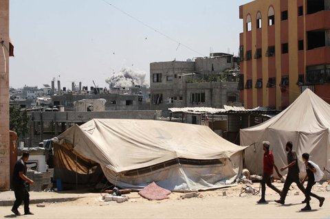 Warga Palestina menyaksikan roket yang ditembakkan pesawat tempur Israel menyasar sebuah gedung di Jabalia, Jalur Gaza utara, Rabu (20/08/2025). <br />AFP/ Bashar Taleb