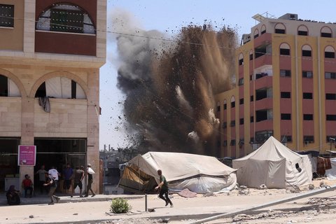 Warga Palestina berlarian saat  roket yang ditembakkan pesawat tempur Israel menyasar sebuah gedung di Jabalia, Jalur Gaza utara, Rabu (20/08/2025). <br />AFP/ Bashar Taleb