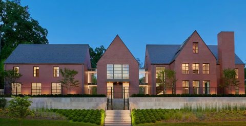 Rumah bata merah modern dengan pencahayaan elegan malam hari